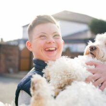 Image: Boy with Down Syndrome hugs dog.