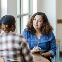 A young woman talks with an older counselor in Denver to make the transition from inpatient substance use treatment to community living