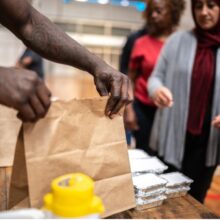 A volunteer hands out a bag of food at a food bank in Colorado