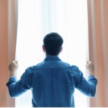 A man looks out the window in Colorado after receiving support to transition from institutional care to life in his community.